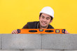 Up-beat mason using spirit-level on wall