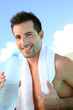 Handsome man drinking water after exercising