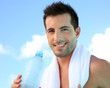 Handsome man drinking water after exercising