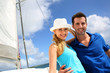 Smiling rich young couple on a sailboat in Caribbean sea