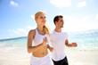 Foto: Young couple jogging on the beach in morning time Young couple jogging on the beach in morning time