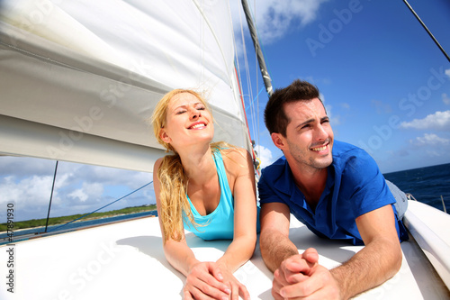 Photo: Smiling couple relaxing on a yacht by sunny day Smiling couple relaxing on a yacht by sunny day