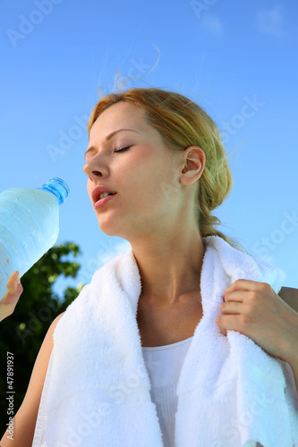 Photo: Portrait of fitness girl drinking water after exercising Portrait of fitness girl drinking water after exercising