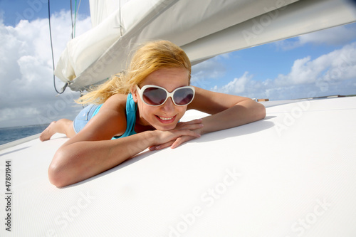 Photo: Young woman with sunglasses relaxing on yacht Young woman with sunglasses relaxing on yacht