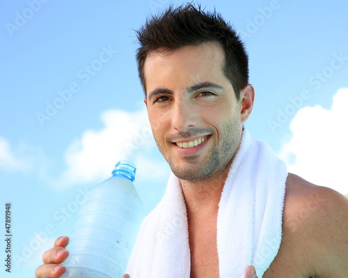 Photo: Handsome man drinking water after exercising Handsome man drinking water after exercising
