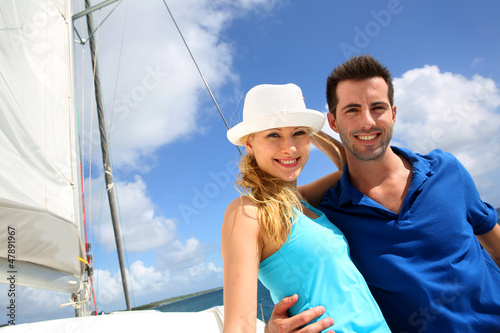 Photo: Smiling rich young couple on a sailboat in Caribbean sea Smiling rich young couple on a sailboat in Caribbean sea