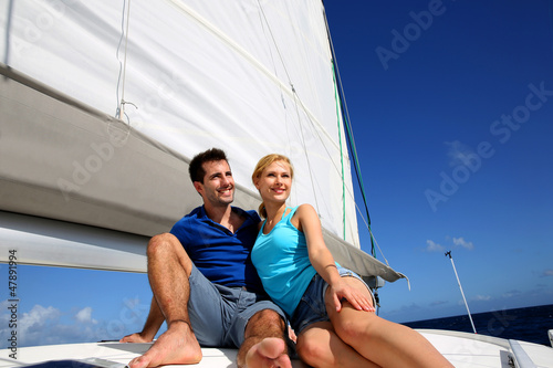 Photo: Portrait of couple sitting on the top of sailing boat Portrait of couple sitting on the top of sailing boat