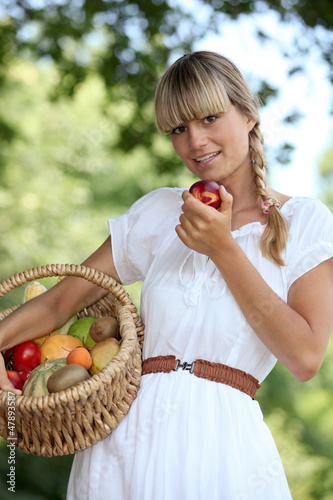 Photo: Blond woman carrying fruit basket Blond woman carrying fruit basket