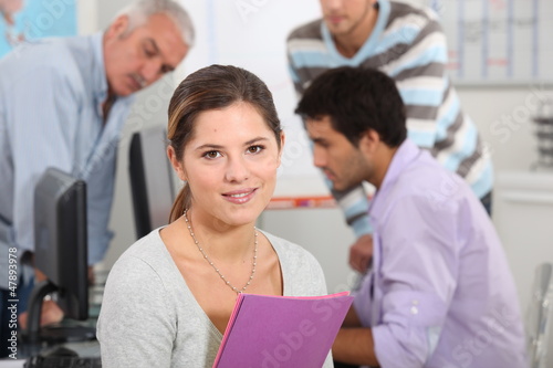 Photo: Woman surrounded by her colleagues at work Woman surrounded by her colleagues at work