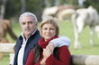 Photo: Couple standing in front of field of horses Couple standing in front of field of horses