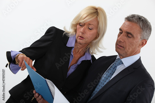 Photo: Business professionals discussing a report Business professionals discussing a report