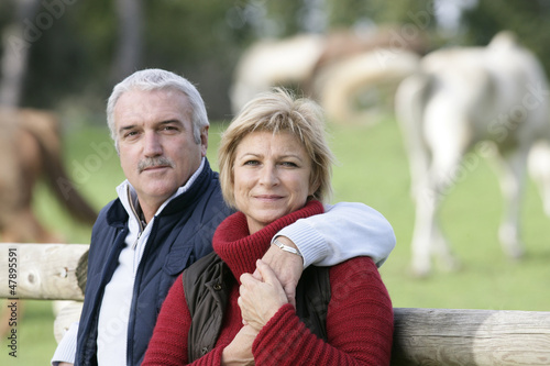 Photo: Couple standing in front of field of horses Couple standing in front of field of horses