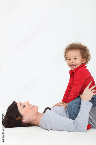 Photo: Mother resting son on belly Mother resting son on belly
