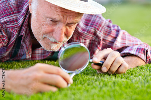 Photo: Close up of senior gardener cutting grass Close up of senior gardener cutting grass