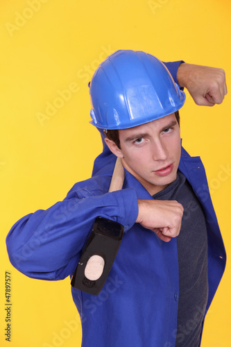 Photo: Tradesman holding a mallet on his shoulders Tradesman holding a mallet on his shoulders