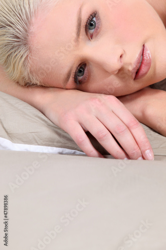 Photo: A portrait of a blond model on her bed. A portrait of a blond model on her bed.