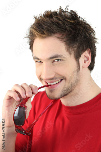 Photo: Trendy young man posing with sunglasses Trendy young man posing with sunglasses