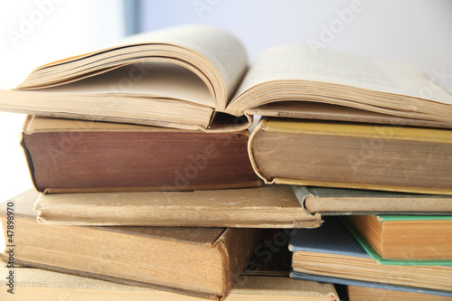 Photo: piles of old books with one open piles of old books with one open