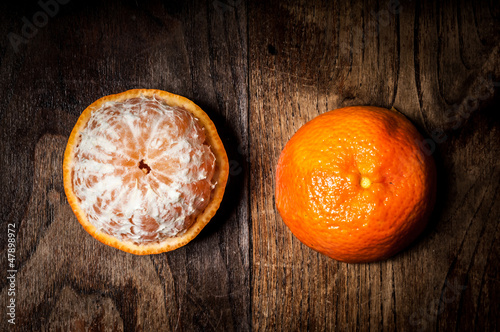 Photo: peeled mandarin with leaf on wood peeled mandarin with leaf on wood