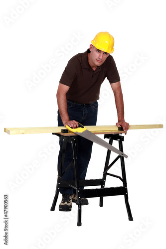 Photo: A carpenter with a handsaw. A carpenter with a handsaw.
