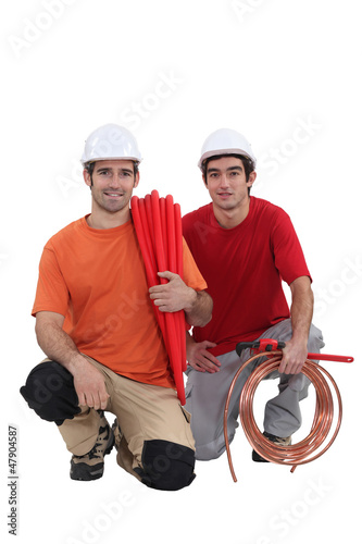 Photo: Kneeling tradesmen holding building materials and tools Kneeling tradesmen holding building materials and tools