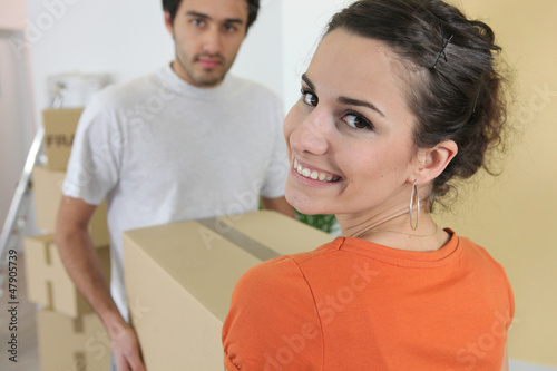 Photo: Couple carrying brown boxes Couple carrying brown boxes