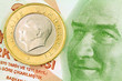 1 Turkish Lira coin on banknote money background