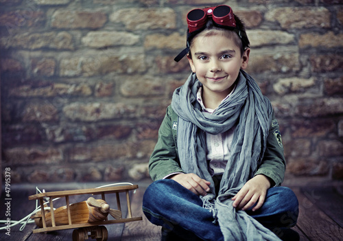 Photo: Cute smiling boy with wooden plane Cute smiling boy with wooden plane