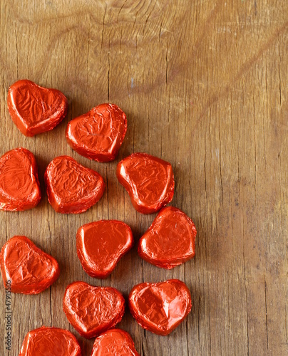 Photo: chocolates in heart shape on a wooden background chocolates in heart shape on a wooden background