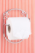 Roll of toilet paper on  holder fixed to pinstriped wall