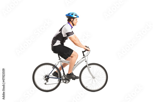 Photo: A young male bicyclist riding a bicycle A young male bicyclist riding a bicycle