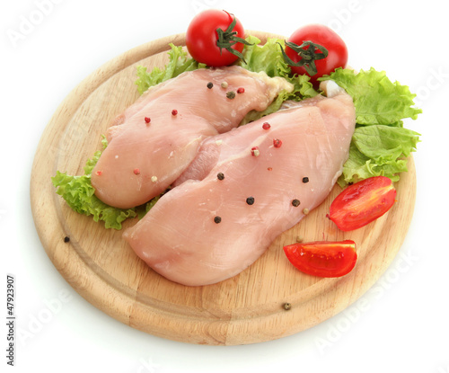 Photo: raw chicken meat on cutting board, isolated on white raw chicken meat on cutting board, isolated on white