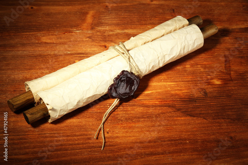 Photo: Old scroll, on wooden background Old scroll, on wooden background