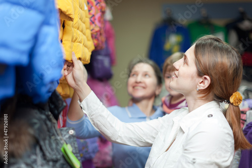 Photo: family chooses winter wear at clothes store family chooses winter wear at clothes store