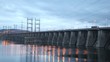 Cars go on bridge in night which is also spillway dike