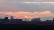City stand against sky on sunset where sun hides at clouds
