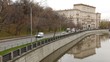 Cars go on river Jauza embankment in front of old building