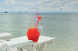 Red cocktail on white table set over ocean