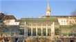 People walk in Palmenhaus which stands in Hofburg Palace park