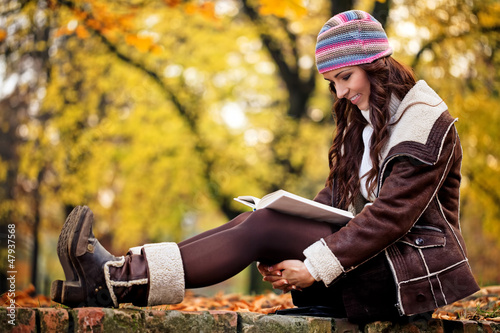 Photo: Pretty woman reading book and smiling Pretty woman reading book and smiling