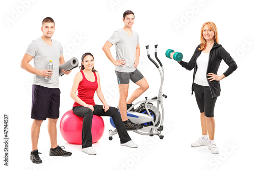 Photo: A small group of athletes posing with a fitness equipment A small group of athletes posing with a fitness equipment
