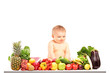Photo: Baby boy sitting on a table full of different fruits and vegetab Baby boy sitting on a table full of different fruits and vegetab