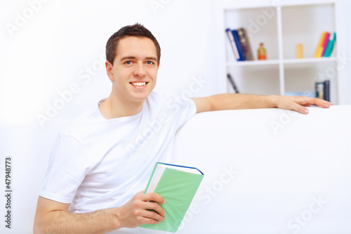 Photo: Young man at home with a book Young man at home with a book