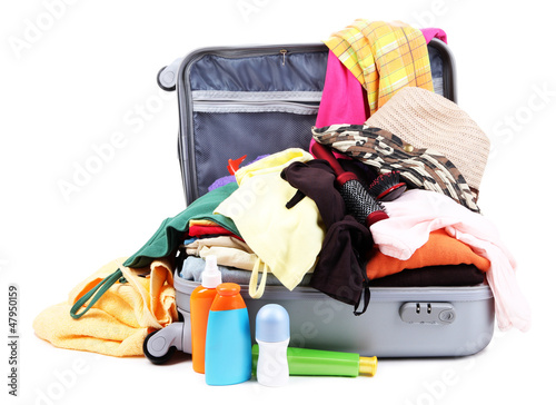 Photo: Open silver suitcase with clothing isolated on white Open silver suitcase with clothing isolated on white