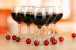 Red wine in glass on room background