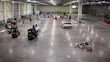 Two loaders stand in large empty hangar