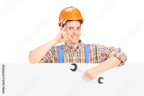 Photo: Male construction worker standing behind a panel Male construction worker standing behind a panel