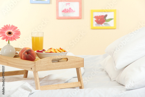 Photo: wooden tray with light breakfast on bed wooden tray with light breakfast on bed