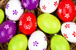 bemalte bunte Eier für Ostern versteckt im Nest aus Stroh