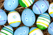 bemalte bunte Eier für Ostern versteckt im Nest aus Stroh